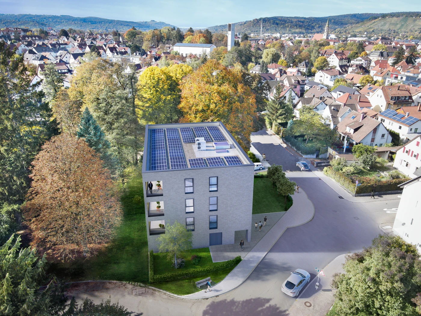 Luftaufnahme eines modernen, dreistöckigen Gebäudes, das von SCHATZ Architektur entworfen wurde und über Solarmodule auf dem Dach verfügt; es ist von Bäumen und Wohnhäusern in einem Vorort von Schorndorf umgeben; das Projekt unterstreicht die fachliche Kompetenz im Bereich der Generalplanung.
